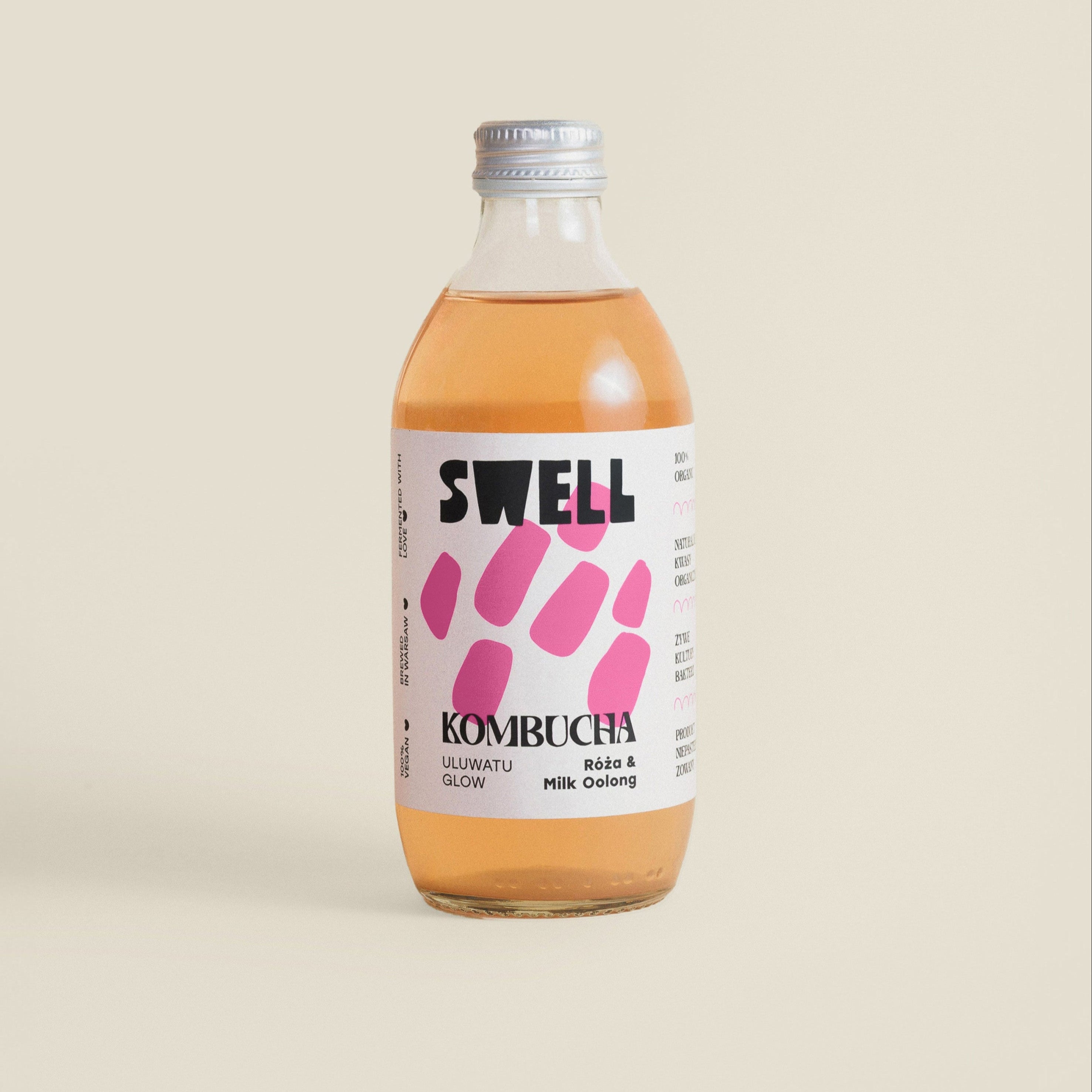 Butelka kombuchy róża-milk oolong, zdjęcie na beżowym tle