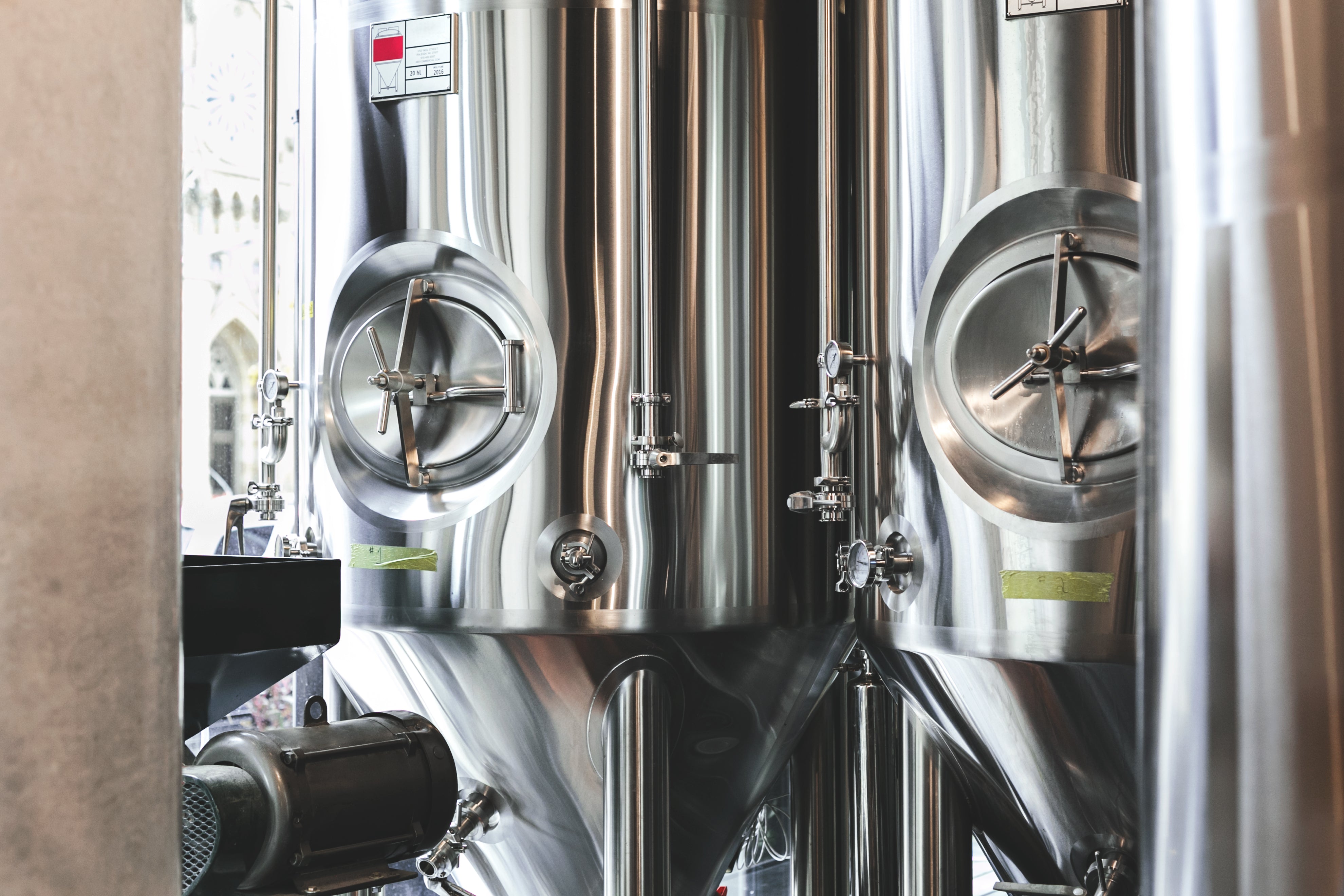 Dwa fermentatory ze stali nierdzewnej stojące obok siebie